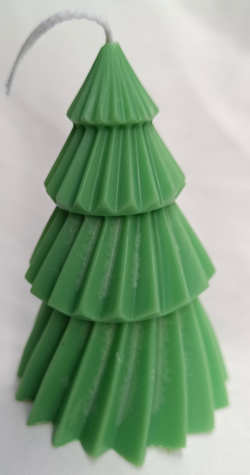 Vela de árbol de Navidad verde como centro de mesa festivo, decorando un ambiente navideño tradicional.