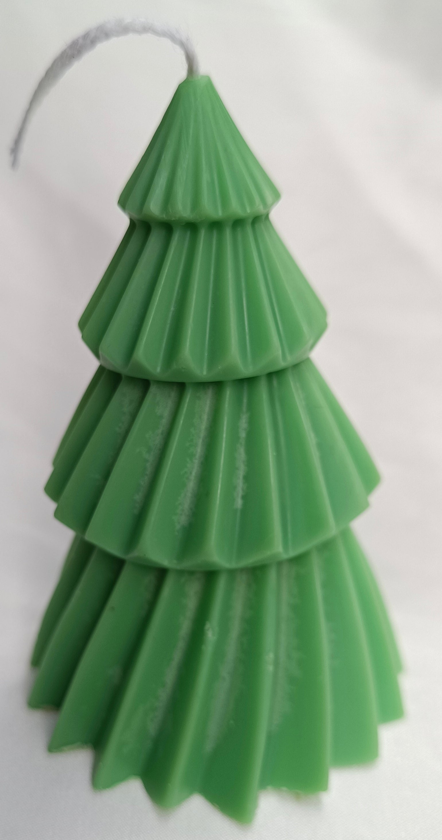 Vela de árbol de Navidad verde como centro de mesa festivo, decorando un ambiente navideño tradicional.