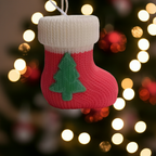Vela Calcetín Navidad Artesanal roja con adorno de árbol verde, sobre fondo de luces bokeh.