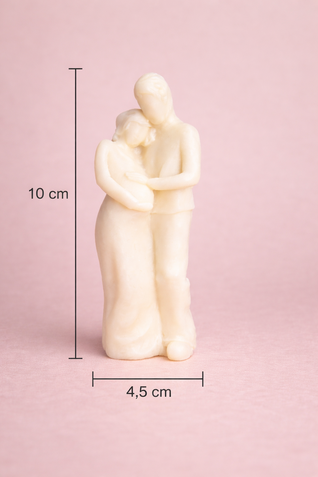 Vela artística en forma de pareja abrazada con diseño contemporáneo, 10 cm de altura y 4,5 cm de ancho, fabricada en cera natural, fotografía de producto premium con fondo rosa suave.