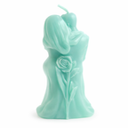 Vela decorativa verde menta vista posterior con silueta de pareja entrelazada y rosa tallada en la espalda, escultura romántica en cera artesanal de acabado satinado, objeto de diseño contemporáneo para interiorismo sofisticado.