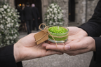 Entrega de vela recuerdo funerario artesanal en manos de asistentes, pequeño obsequio conmemorativo presentado en ceremonia de despedida.