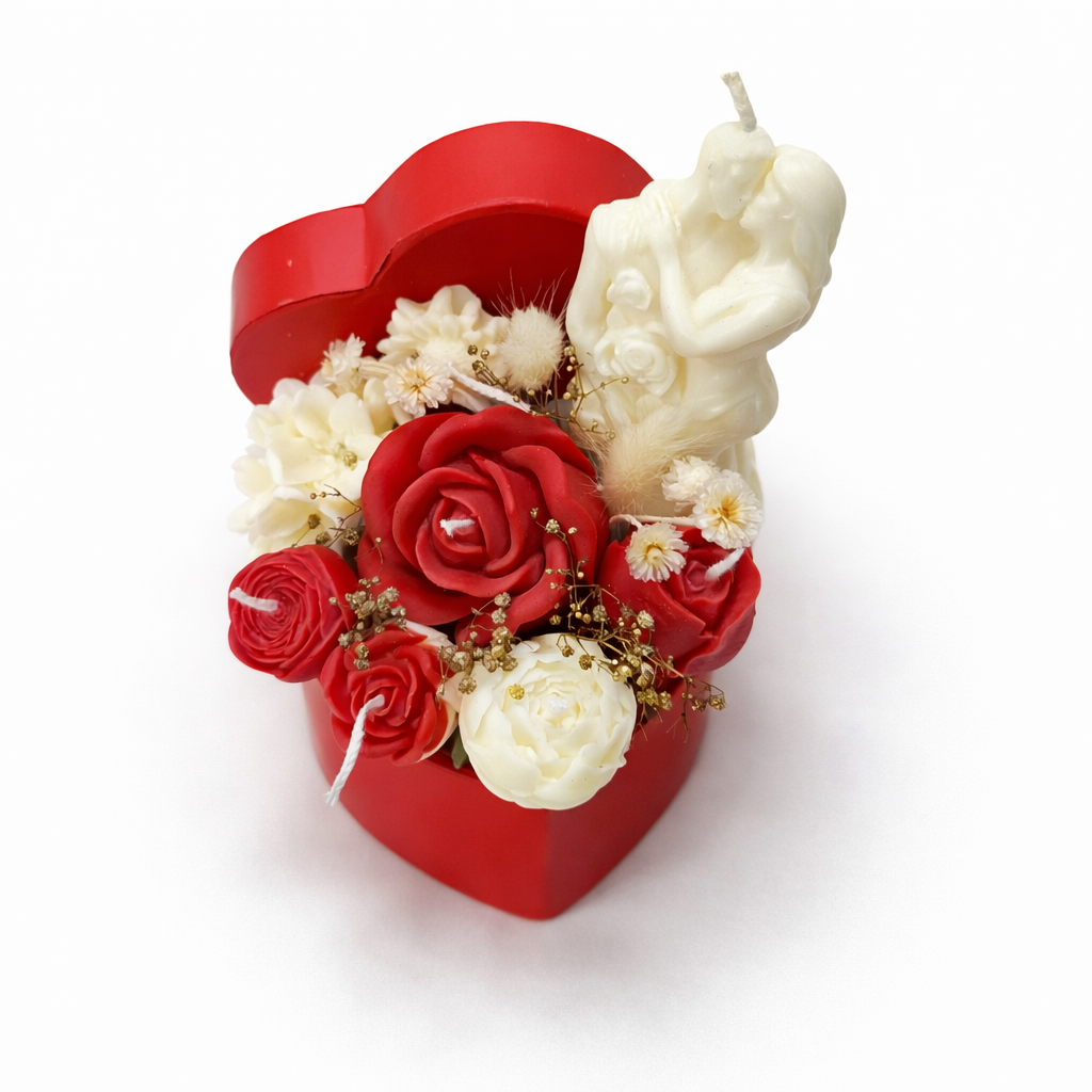 Centro Promesa en composición romántica con velas florales rojas y blancas y figura de pareja, resaltado sobre fondo oscuro para contraste