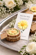 Composición de recordatorio funerario de lujo con tarjeta conmemorativa y vela artesanal floral sobre bandeja decorada con flores blancas, homenaje elegante y emotivo.
