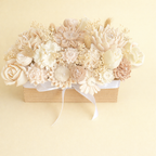 Centro floral de velas artesanales en tonos beige, crema y marrón suave, composición elegante de 25 flores talladas a mano en base rectangular, ideal para decoración de boda sofisticada y mesa imperial.
