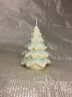 Vela de Navidad con forma de árbol y copos de nieve azules pintados a mano.