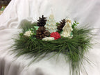 Velas decorativas de Papá Noel y árbol de Navidad sobre una base de pino.