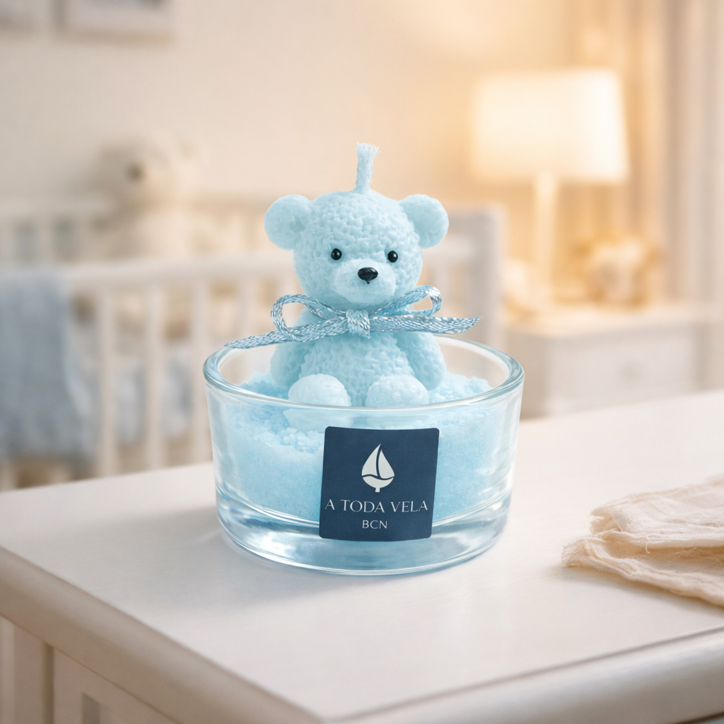 Vela decorativa con osito azul pastel en vaso de cristal, presentada en ambiente infantil luminoso y acogedor, fotografía lifestyle de lujo con estética suave y emocional.