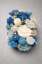 Centro decorativo de velas en forma de flores azules y blancas ideal para bodas tendencia 2026