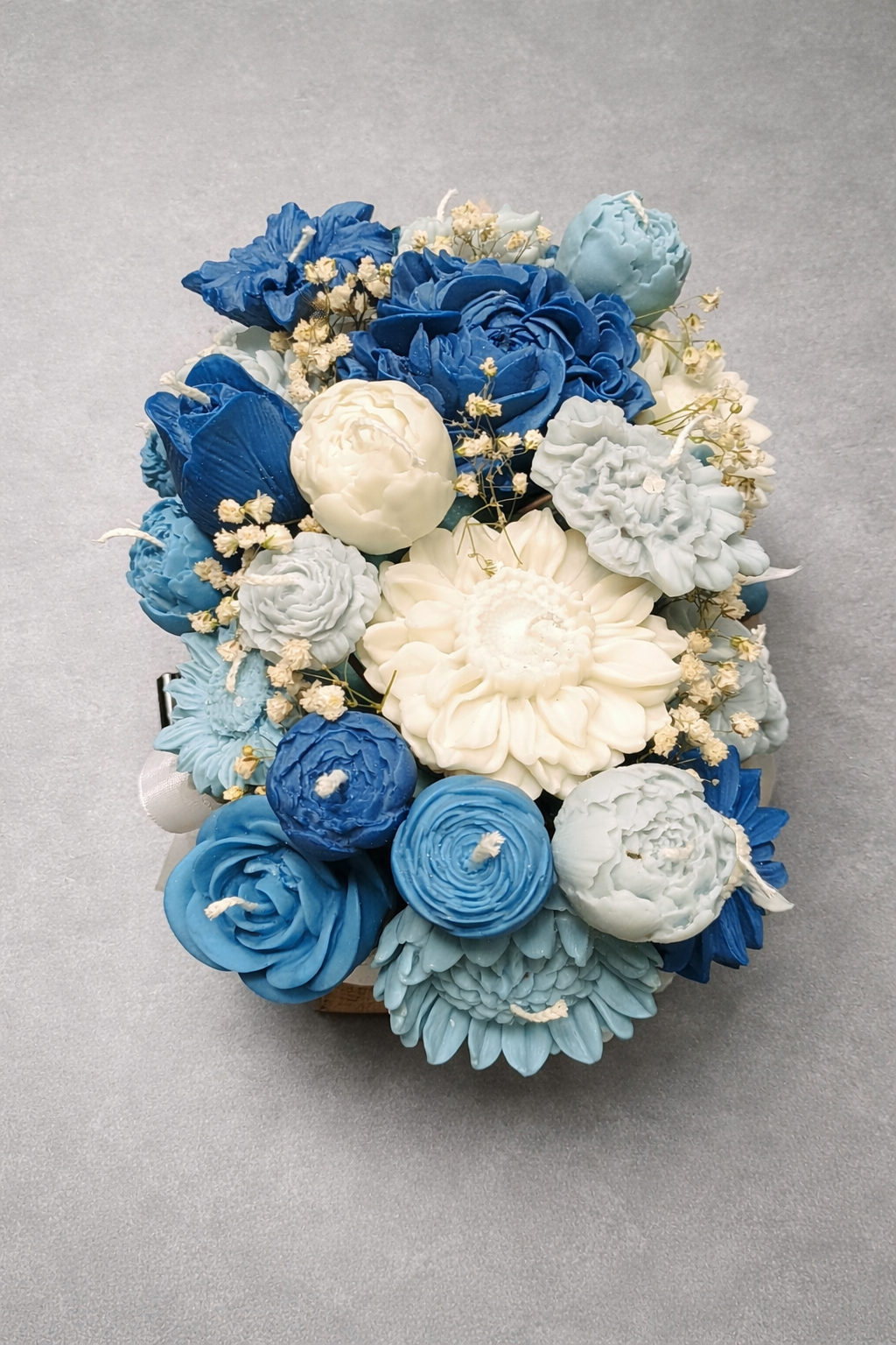Centro decorativo de velas en forma de flores azules y blancas ideal para bodas tendencia 2026