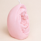 Vela religiosa artesanal en color rosa pastel con relieve de Sagrada Familia, diseño escultórico en cera natural, recuerdo exclusivo para eventos especiales.