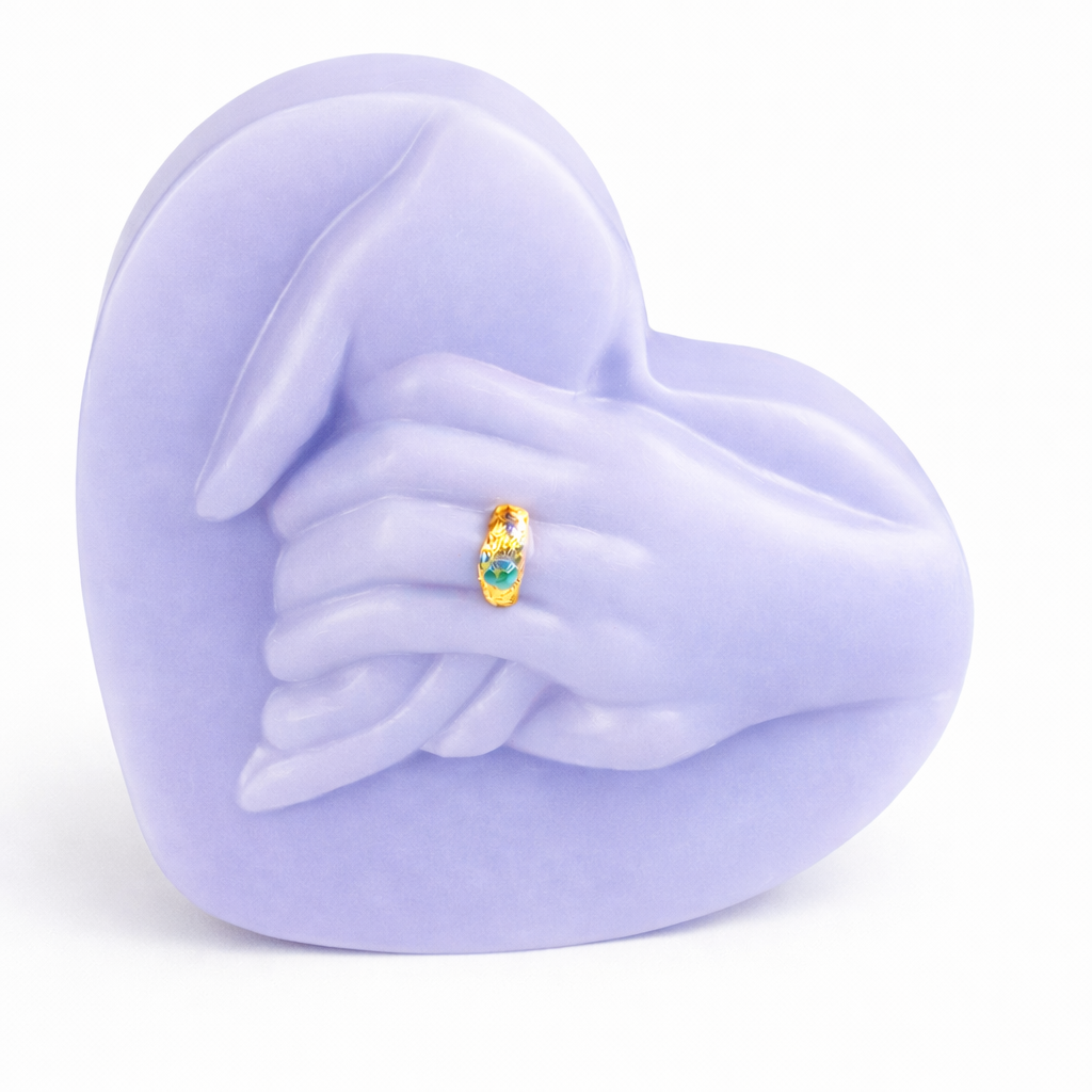 Vela decorativa en forma de corazón con manos entrelazadas color lila pastel, elaborada en cera natural ecológica, diseño artístico romántico con anillo dorado, objeto de lujo ideal para decoración elegante y regalo especial.