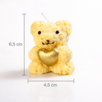 Vela decorativa artesanal con forma de osito y corazón dorado, dimensiones 6,5 cm de altura y 4,5 cm de ancho, fotografía de estudio minimalista para e-commerce de lujo.