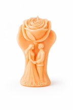 Vela decorativa romántica en tono naranja cálido con figura de pareja bajo rosa en relieve, fabricada en cera natural premium, diseño escultórico con inscripción “God is Love”, pieza elegante para aniversario, boda o decoración espiritual sofisticada.