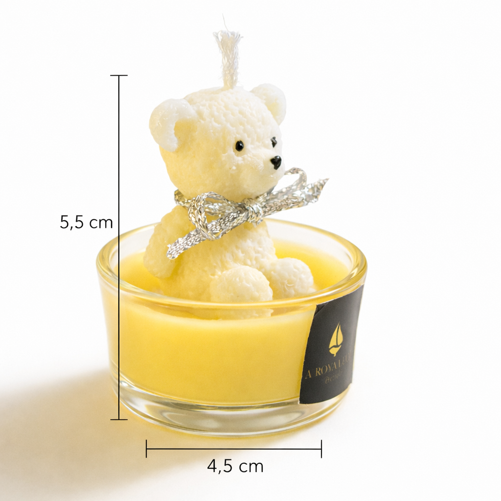 Vela decorativa con osito de cera artesanal en vaso de cristal, dimensiones 5,5 cm de altura y 4,5 cm de diámetro, diseño infantil elegante y fotografía de producto premium sobre fondo blanco.
