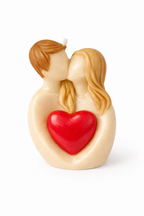 Vela de diseño romántico con pareja besándose y corazón rojo intenso, escultura artística en cera premium con acabado suave, pieza decorativa moderna para regalo de amor exclusivo, fotografía editorial fondo neutro.