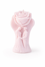 Vela romántica color rosa empolvado con pareja de novios en relieve y rosa tallada superior, realizada en cera natural ecológica, diseño artístico delicado con mensaje “God is Love”, regalo exclusivo para bodas, compromiso o decoración elegante.