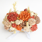Vista superior de centro floral de velas terracota y crema envolvente – tendencia cromática bodas 2026