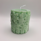Vela Muñeco Nieve Copos cilíndrica, verde menta con relieve detallado de muñeco de nieve y copos.