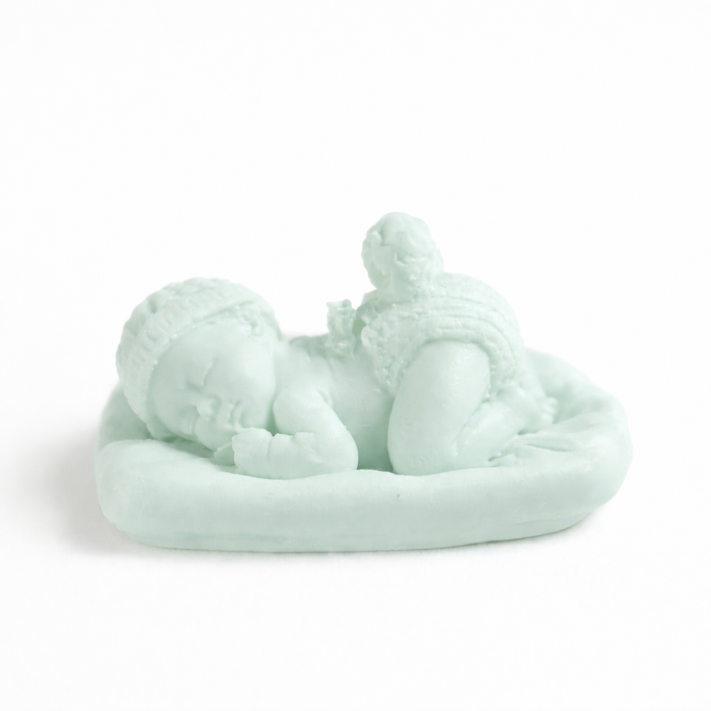 Vela decorativa artesanal en forma de bebé dormido verde menta, diseño delicado en cera premium ideal para recuerdo elegante de bautizo.