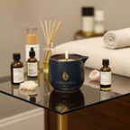 Vela Masaje Mai no Kaori encendida, en vaso cerámico azul marino, rodeada de aceites esenciales y toallas para un ritual de spa.